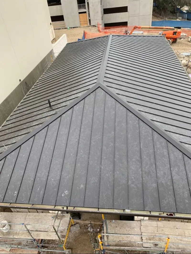 Commercial metal roof construction with crane equipment in Hondo